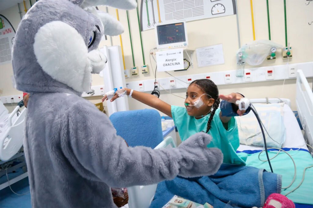 Crianças recebem visita do coelhinho da páscoa em hospitais do SUS.